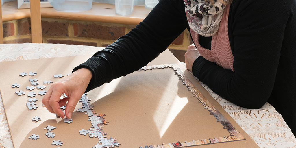 'Image displaying woman completing a jigsaw puzzle'